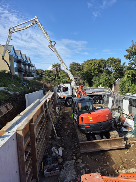 Concrete pump truck working over a house on a tight access site